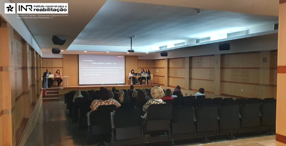 Fotografia da Sessão com a Equipa a fazer apresentação e o auditório com pessoas a assistir